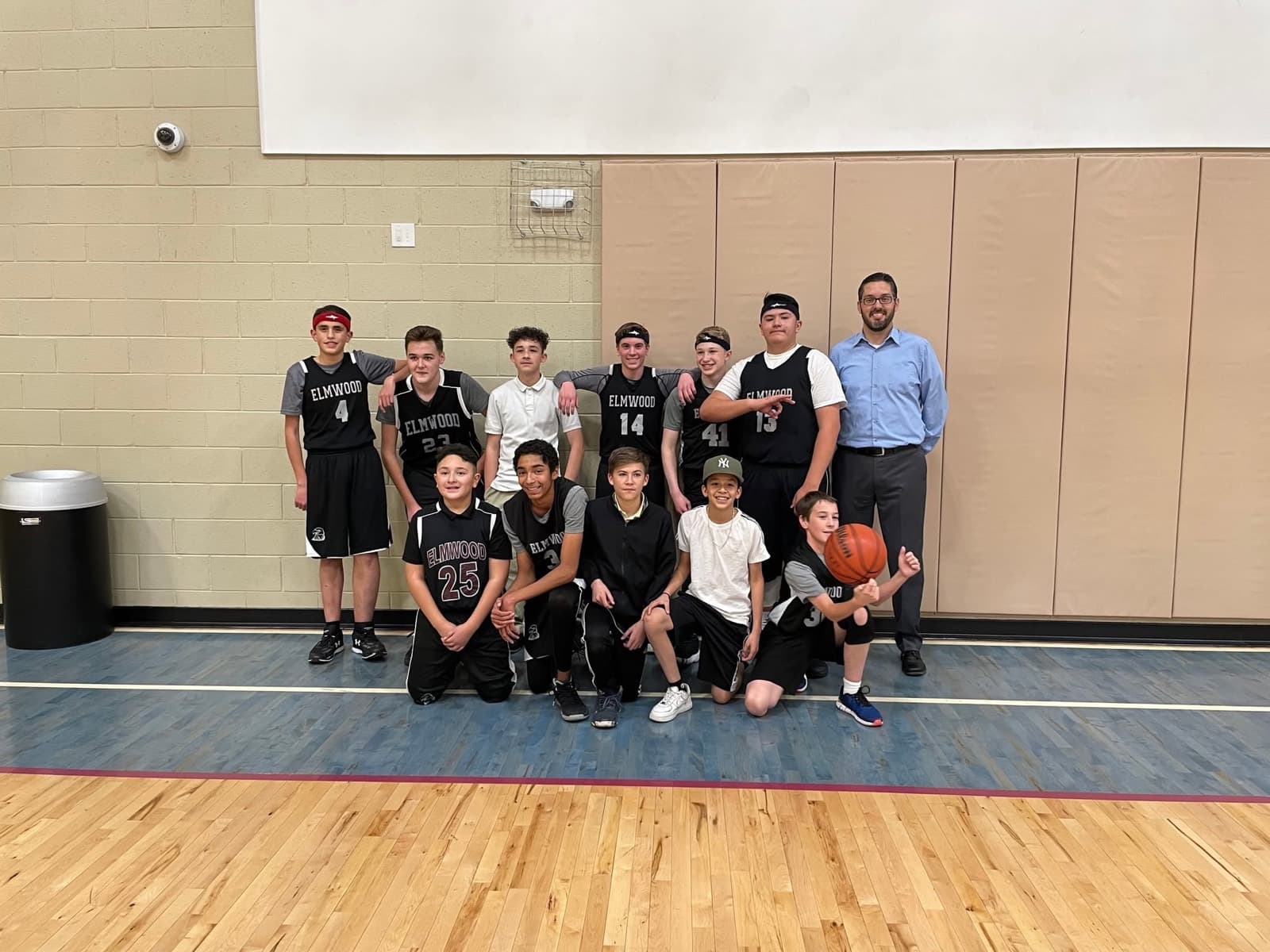 The Elmwood Eagles boys basketball team with their coach
